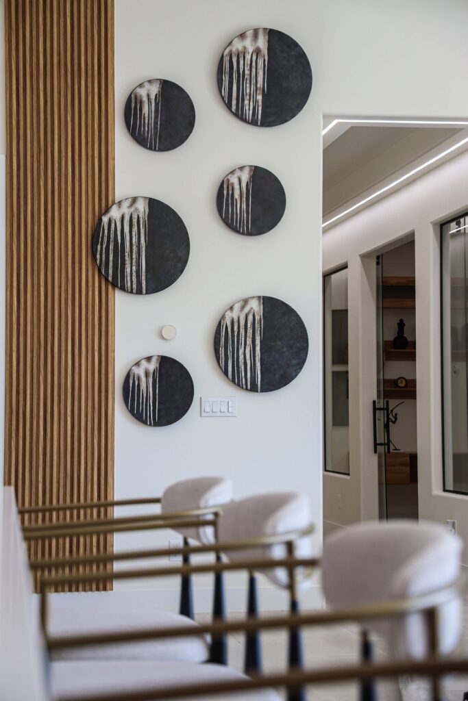 Entry hall detail with a wood slat feature wall and round decorative art