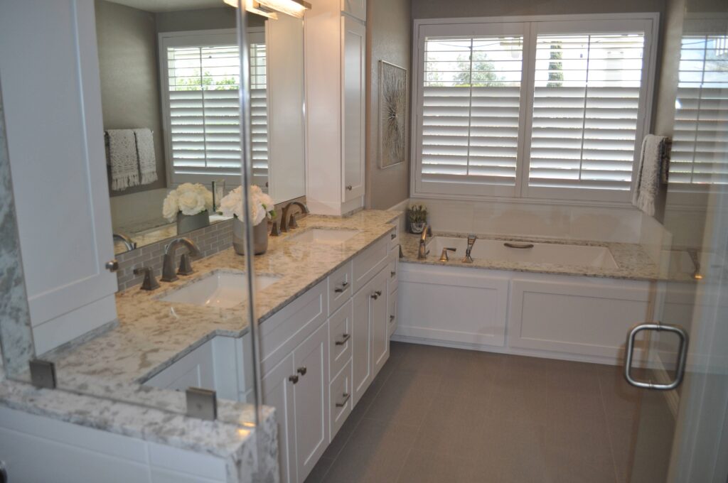 Bathroom double vanity with granite counters and plantation shutters