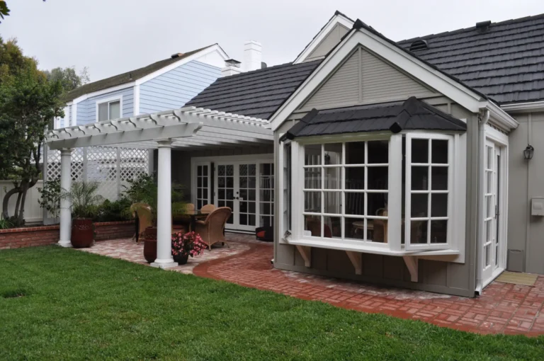 Home exterior with a bay window, white patio cover and landscaped garden