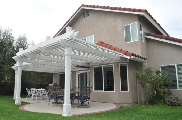 White patio cover with open rafters attached to the rear of a home